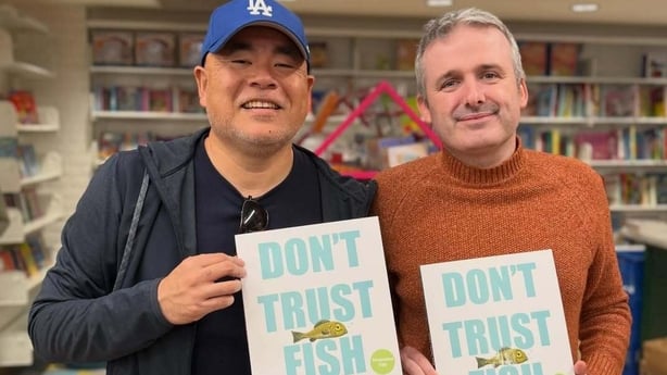 Dan Santat and Neil Sharpson pose with their book Don't Trust Fish
