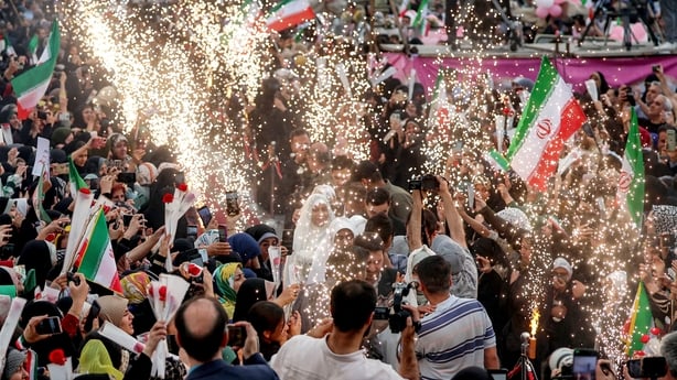 Sparks fly as bride and groom couples arrive for a public mass wedding ceremony at Imam Hossein Square in Tehran