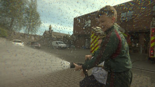 A young boy sprays a fire house as part of a demonstation from Dublin Fire Brigade
