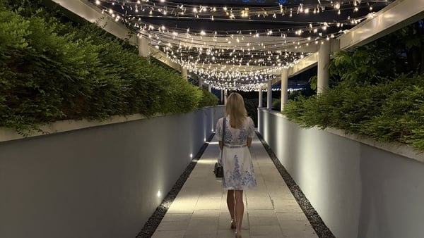 woman walking under lights