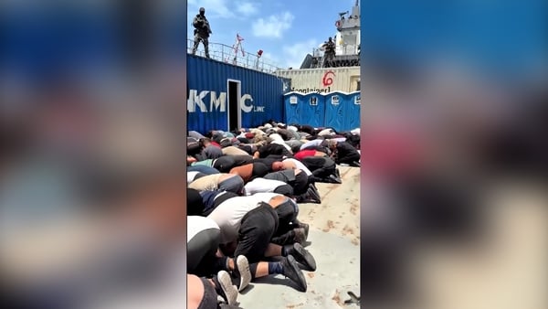 Dozens of people are detained on their hands and knees by Israeli soldiers