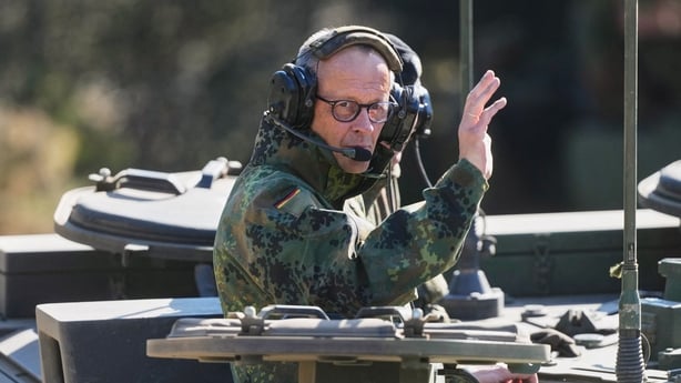 German Chancellor Friedrich Merz waves as he is driven in a GTK Boxer tank at the German army barracks in Munster, northern Germany, on April 30, 2026, as they visit the troops of the German Army. (Photo by Markus Schreiber / POOL / AFP)