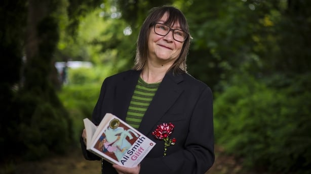 Woman standing outdoors holding book