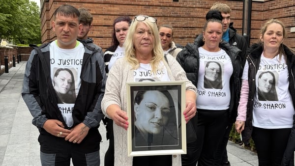 Catherine Crean is pictured holding a picture of her daughter Sharon Crean outside court