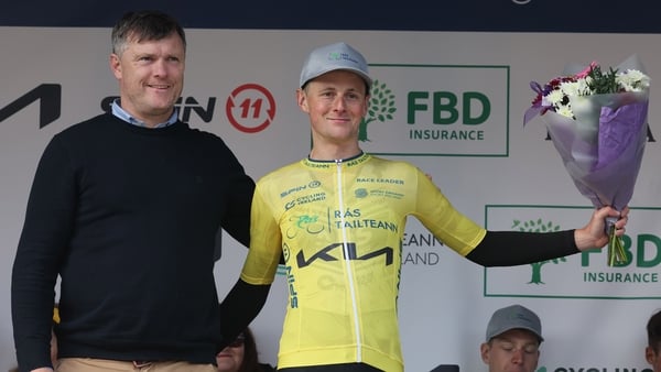 Rás Tailteann 21/5/2026 Stage 2 Rathmore - Banteer Patrick Coleman of Kia motors presents Adam Lewis of USA: APS Pro Cycling team with the Kia Motors Race leaders jersey Photo Lorraine O'Sullivan