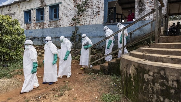 Health workers wearing protective equipment walk outside the General Referral Hospital of Mongbwalu during the Ebola outbreak response in Bunia, Democratic Republic of Congo.
