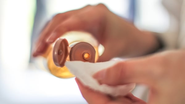 A woman applying toner to a cotton pad