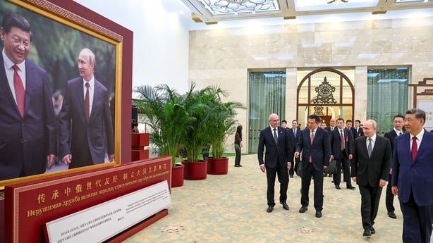 In this pool photograph distributed by the Russian state agency Sputnik, Russia's President Vladimir Putin and China's President Xi Jinping tour a photo exhibition on Russia-China ties in Beijing on May 20, 2026. (Photo by Alexander KAZAKOV / POOL / AFP)