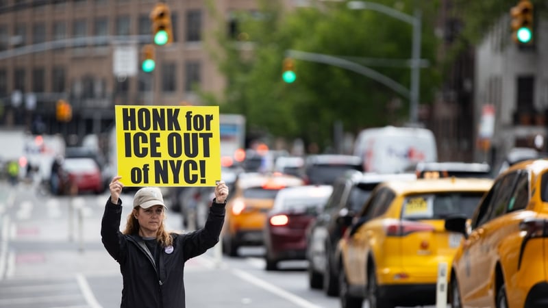 A woman holds a banner in Manhattan against ICE