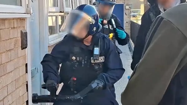 A Norwich police man breaks down a door in relation to a child exploitation proble