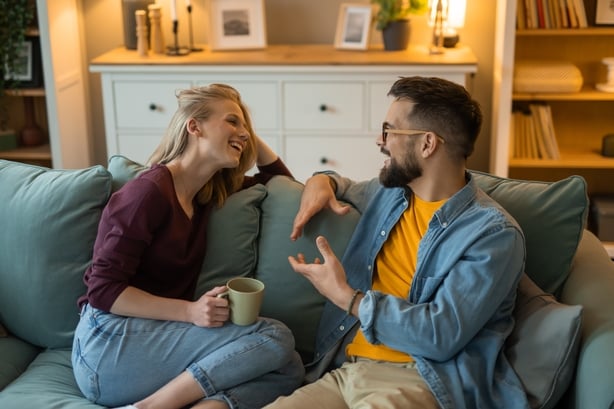 Happy couple enjoying a discussion while relaxing together on a cozy sofa at home