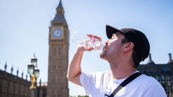 A man cools down with a bottle of water during the hot weather in Westminster Bridge, central London