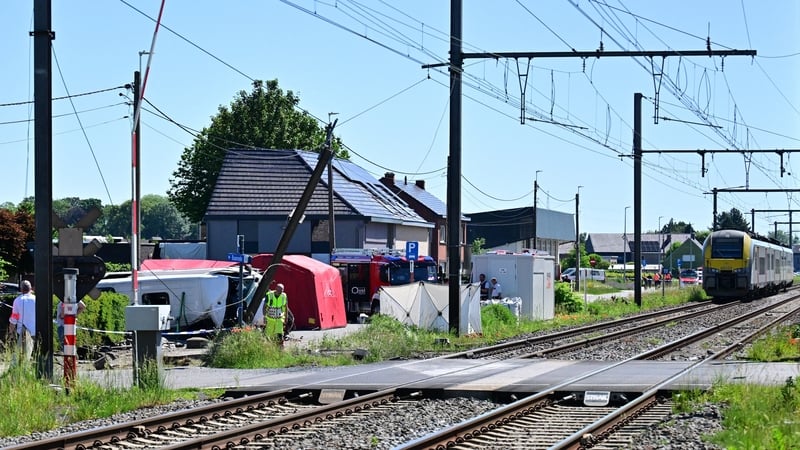 Emergency services are pictured attending the scene of a crash between a school bus and a train in Belgium