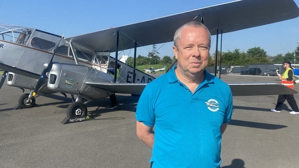 a photo of a pilot called brendan bruton in front of a vintage plane