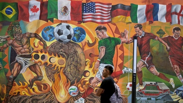 A man stands in front of a hand-painted mural featuring 2026 World Cup motifs in Mexico City on May 25, 2026, this work covers over 200 square meters and was painted by the artists Josa Cruz Pacheco, Andreee Orozco, Francisco Thomas Arriaga, Vivian Velazq