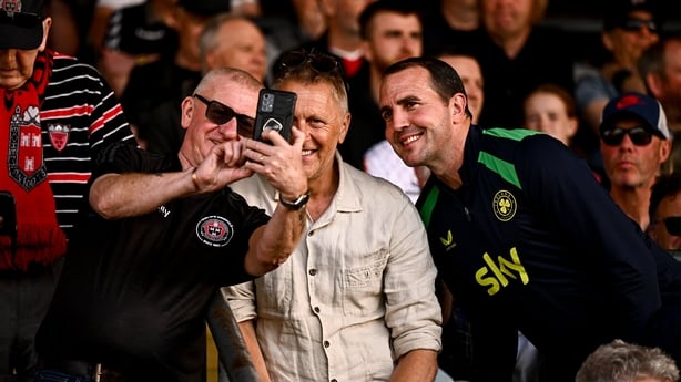 Republic of Ireland head coach Heimir Hallgrimsson, centre, and assistant coach John O'Shea take a selfie with Bohemians supporter Davy Keogh before the SSE Airtricity Men's Premier Division match between Bohemians and Shamrock Rovers at Dalymount Park in Dublin.