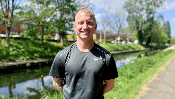 Chris Connolly is pictured from waist up, standing in front of the Grand Canal in Dublin