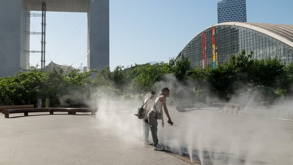 Workers cool themselves in water fountains during high temperatures in the La Defense business district of Paris, France, on Tuesday, May 26, 2026. The first major heat wave of the season broke temperature records across northwest Europe, triggered water