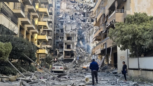 Debris and rubble are seen as people view a destroyed building after an airstrike in Lebanon