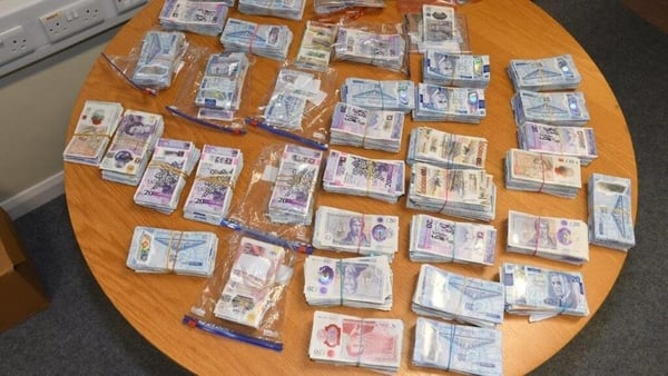 Cash seized by gardaí is laid out on a table