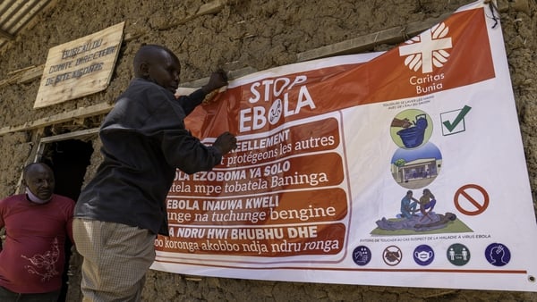 A man hangs an Ebola awareness banner in the Kigonze camp for displaced people in Bunia, eastern DRC
