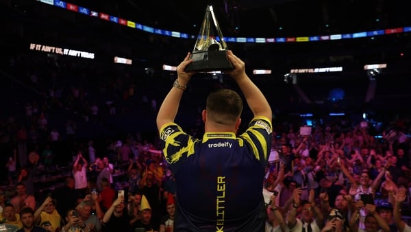 Luke Littler poses with the Premier League trophy after victory over Luke Humphries