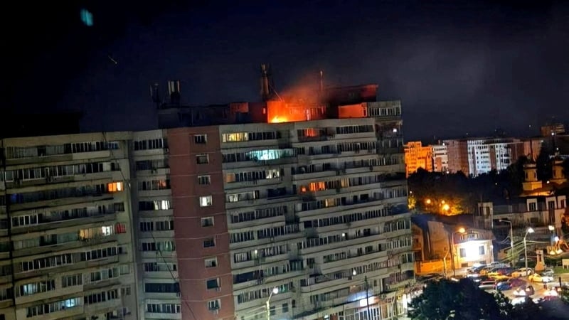 A fire burns on the roof of a 10-story block of flats after a drone crashed into the building, causing an explosion and injuring two people, near the border with Ukraine, in Galati, Romania