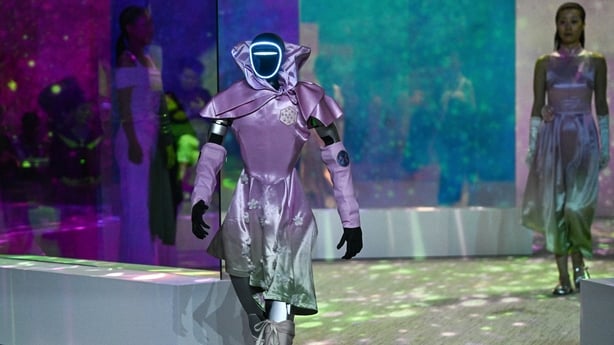 A humanoid robot and fashion model walk the runway in South Korea