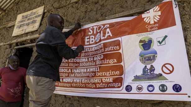 A man hangs an Ebola awareness banner in the Kigonze camp in Bunia, in the eastern Democratic Republic of the Congo, 