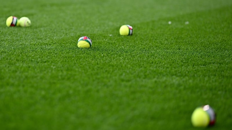Tennis balls on a football pitch featuring a Palestine flag sticker with the words "Stop The Game"