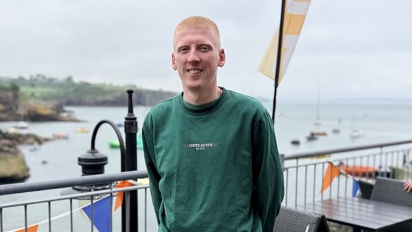 Adam Sweeney is pictured from the waist-up and smiles at the camera