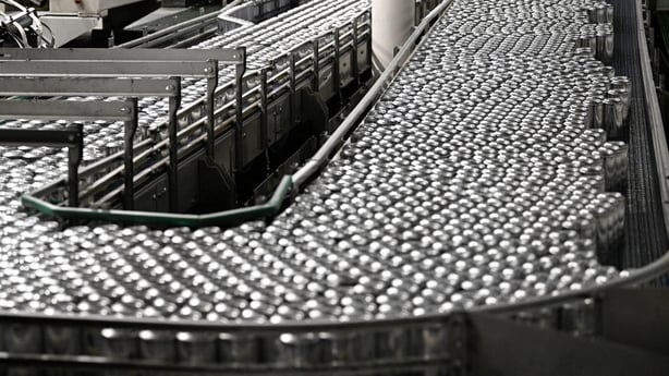 Aluminium cans passing on a production line at the exit of a stretching and trimming machine