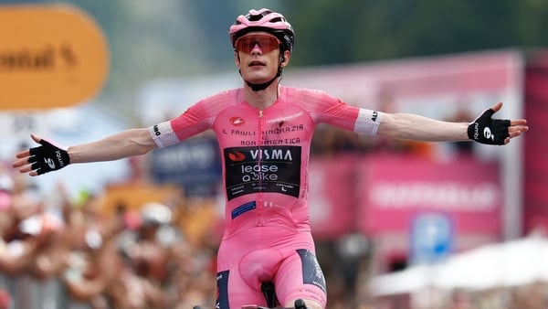 Team Visma Lease a Bike Danish rider Jonas Vingegaard wearing the overall leader's pink jersey celebrates