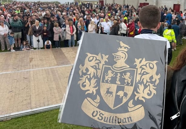 The O'Sullivan clan family crest is held by a participant 