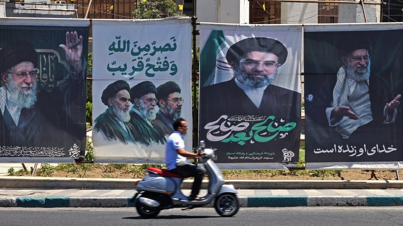 A man rides a scooter past installed banners with pictures of Iran’s slain supreme leader Ayatollah Ali Khamenei and his son and country's's newly nominated supreme leader Ayatollah Mojataba Khamenei at the Sadeghiyeh Square in Tehran on May 31, 2026. Ira