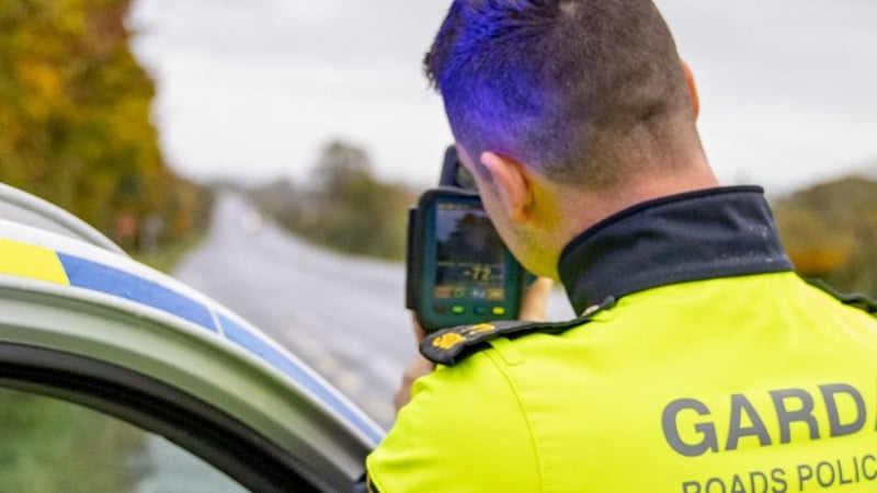 a garda is seen holding a speed detection device