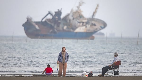 In this picture obtained from Iran's ISNA news agency on June 1, 2026, Iranians sit on Suru Beach in Bandar Abbas along the Strait of Hormuz. The United States and Iran traded strikes as negotiations between the two sides stalled and Tehran again insisted