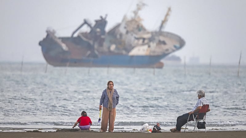In this picture obtained from Iran's ISNA news agency on June 1, 2026, Iranians sit on Suru Beach in Bandar Abbas along the Strait of Hormuz. The United States and Iran traded strikes as negotiations between the two sides stalled and Tehran again insisted