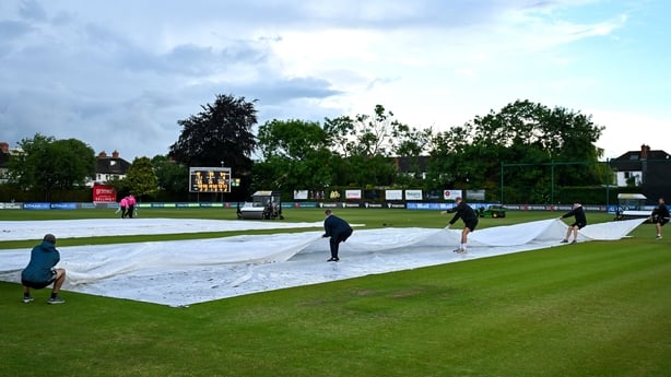 Groundstaff tend to the pitch as rain stops play in Clontarf