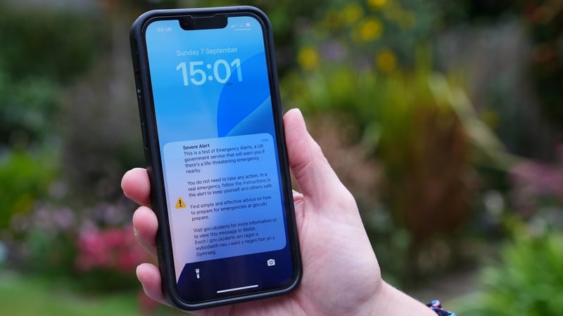A person holding a phone with an emergency alert