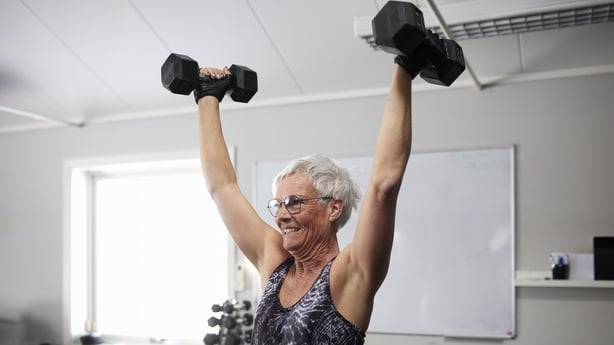 woman exercising with dumbbells at health club