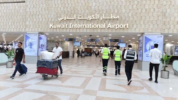 Passengers are seen at Kuwait International Airport in Kuwait City
