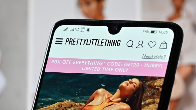 A mobile phone shows the website of online fashion retailer PrettyLittleThing