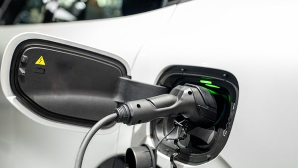 Electric vehicle charging cable connecting to a white car port