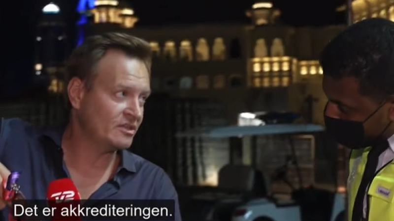 TV2 reporter Rasmus Tantholdt shows his permit to security staff live on Danish television
